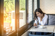 © sunti - Beautiful young woman Playing Mobile with morning coffee
