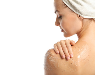 Wall Mural - Young woman applying scrub on shoulder on white background