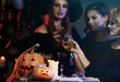 © Africa Studio - People in costumes near table with Halloween decor
