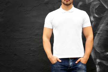 Canvas Print - Young man in blank polo shirt against graffiti wall, closeup