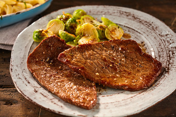 Serving of marinated and cooked minute steak with veggies