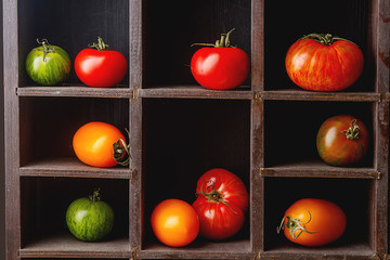 Colorful ripe tomatoes. Delicious vegetarian food. Dark backgrou