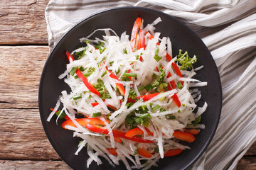 Wall Mural - healthy food: salad of daikon with pepper and herbs closeup. Horizontal top view