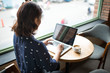 © makistock - Beautiful cute asian young businesswoman in the cafe, using lapt