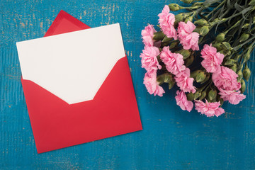 Wall Mural - Carnations flowers and envelope on a table