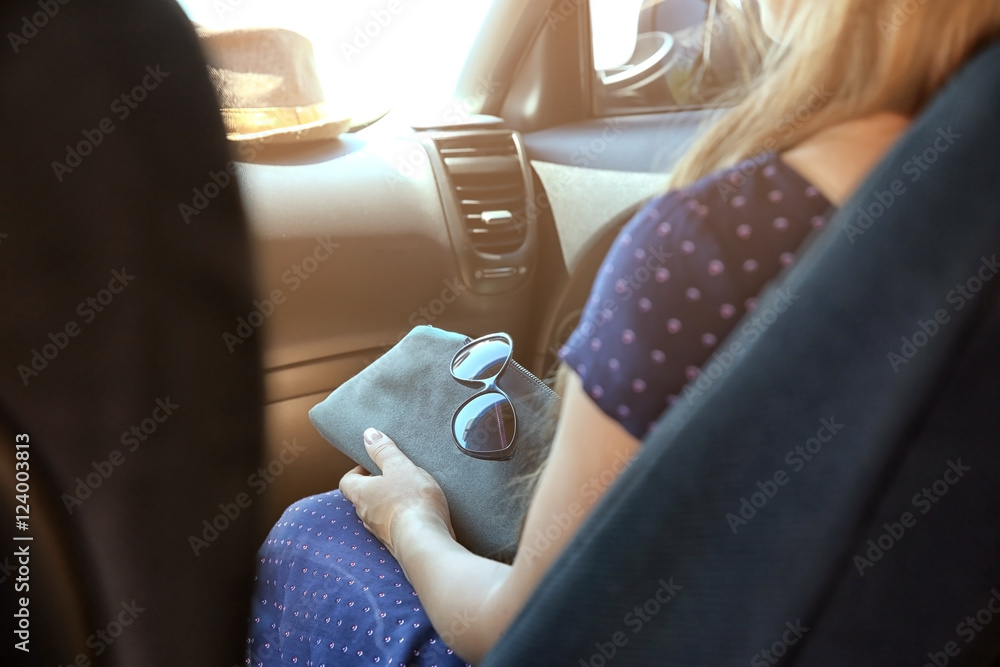 Girl with bag and sunglasses in car