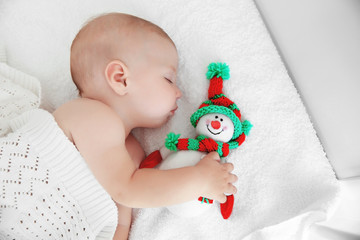 Sticker - Little baby sleeping with toy snowman on white bed