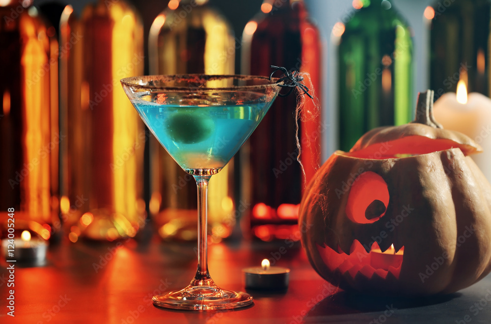 Tasty cocktail and Halloween pumpkin on blurred background