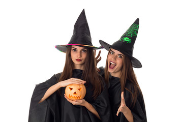 joyful young women with pumpkins in hands