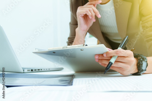 Vászonkép  Business documents on office table with laptop computer,document business diagram and officer working in background,businesswoman meeting business plan