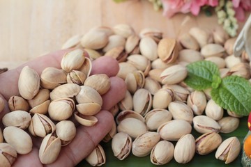 Canvas Print - Pistachio nuts is tasty on wood background.