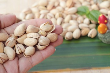 Canvas Print - Pistachio nuts is tasty on wood background.