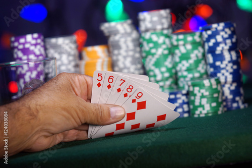 Leinwand Poster Hand holding a Straight Flush in the card game of poker
