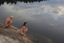 Girls Sitting By The Lake After A Swim; Kristiansand, Norway