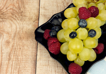 Grapes, raspberries and blueberries on a plate