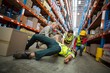 Worker fallen down while carrying cardboard boxes