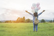 © sunti - Young beautiful woman with colorful balloons on a green meadow