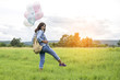© sunti - Young beautiful woman with colorful balloons on a green meadow