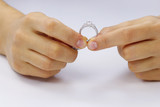 Fototapeta  - Hands holding a ring on a white background