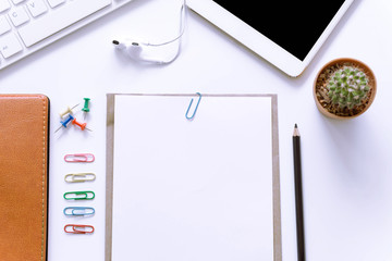 Office desk top view with smartphones, laptop and book / Office supplies Blank and pencil notebook and earphones on white background.