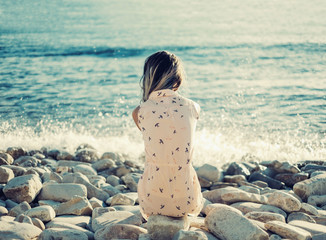 Poster - Young woman resting on pebble beach