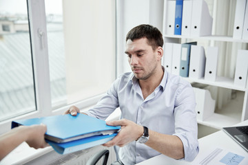 Wall Mural - businessman taking folder from secretary in office