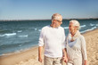 © Syda Productions - happy senior couple walking along summer beach