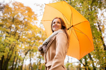 Sticker - happy woman with umbrella walking in autumn park