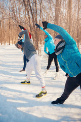 Group of friends stretching in the snow in winter