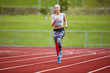 © kjekol - Woman In Sportswear Running On Sports Track