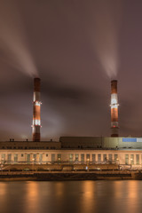 Factory with two smoke stack against sky at night