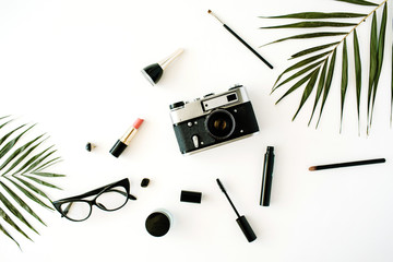 Wall Mural - flat lay feminine arrangement with retro camera, accessories, glasses, cosmetics and palm branches on white, flat lay, top view