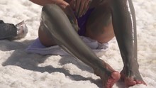 Beautiful Girl Rubs Mud From The Dead Sea On Her Leg.