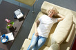 © sepy - Sweet home relax. Top view shot of a beautiful blond woman lying on sofa at home and relaxing.
