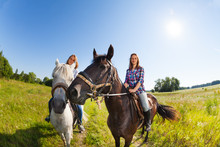 Two Female Horseback Riders Mounted On Horses