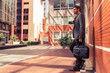 © ADDICTIVE STOCK - Handsome man in suit with briefcase in the street