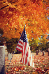 American veteran flag in autumn cemetery. Vintage filter effects.