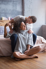 Young couple sitting together in a bedroom