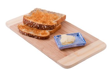 Two slices of bread and butter on wooden board, isolated on white background.