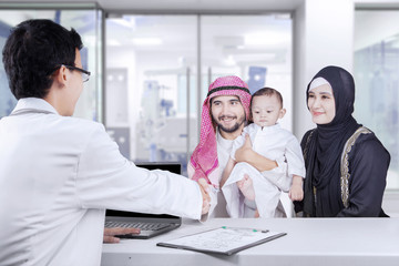 Wall Mural - Middle eastern families handshake with pediatrician