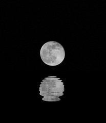huge full moon with the reflection on the water