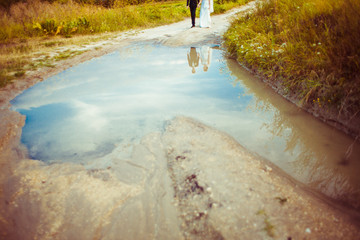 Wall Mural - Reflection of walking wedding couple in the large pool