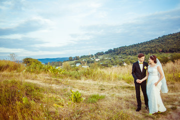 Wall Mural - Autumn blue sky hangs over the wedding couple holding each other