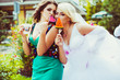© pyrozenko13 - Bride hugs with bridesmaid holding in their hands tasty sugar ca