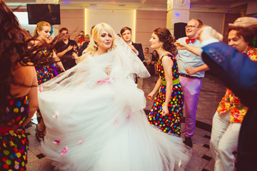 Magnificent bride whirls surrounded by friends