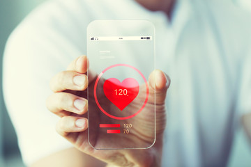 Canvas Print - close up of hand with heart rate on smartphone