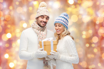 Wall Mural - smiling couple in winter clothes with gift box