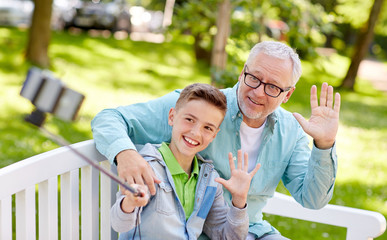 Canvas Print - old man and boy taking selfie by smartphone