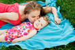 © snedorez - Young woman kissing little girl lying on blue blanket