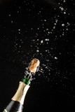 Fototapeta Panele - Closeup of champagne explosion. Vertical image on black background